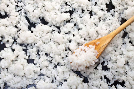 Background of boiled rice with a wooden spoon