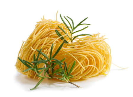 Vermicelli pasta nests with rosemary on a white background