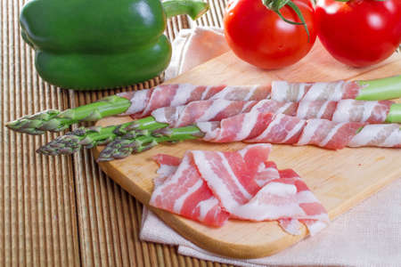 Bacon and asparagus on a wooden background の写真素材