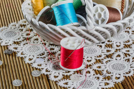 spools of thread on a wooden background 