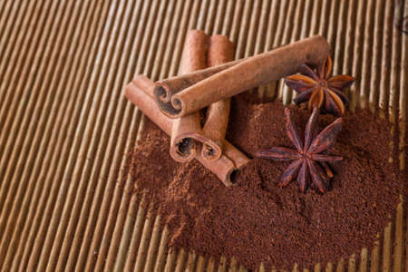 Ground coffee with cinnamon and star anise on a wooden backgroundの写真素材