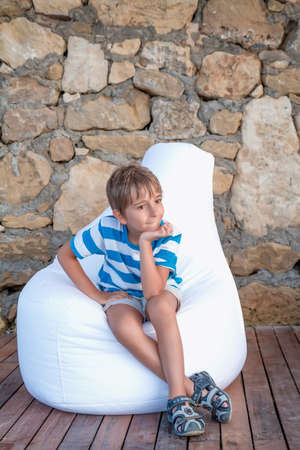 The young man sitting outside on the bagの写真素材