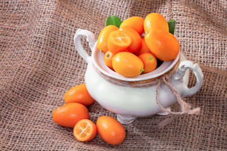 Ripe kumyauat with leaves in a bowl の写真素材