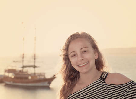 Portrait of a girl on the background of the ocean. Vintage style の写真素材