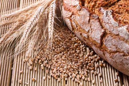 Fresh bread with wheat on the wooden backgroundの写真素材