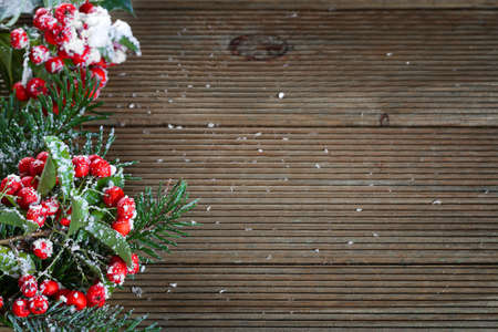 Holly leaves and berries on a wooden backgroundの写真素材