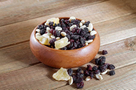 Mixed nuts with raisins close up on a wooden backgroundの写真素材