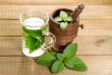 Mint tea with fresh mint leaves on a wooden backgroundの写真素材