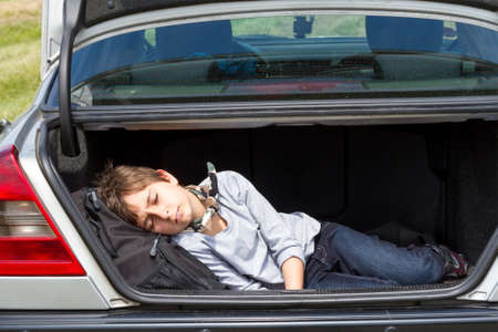 Sleeping boy in the trunk of a carの写真素材