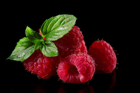 Ripe raspberry with mint leaves on a black backgroundの写真素材