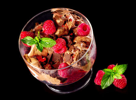 Chocolate ice cream with fresh raspberries isolated on a black background. Top view.の写真素材