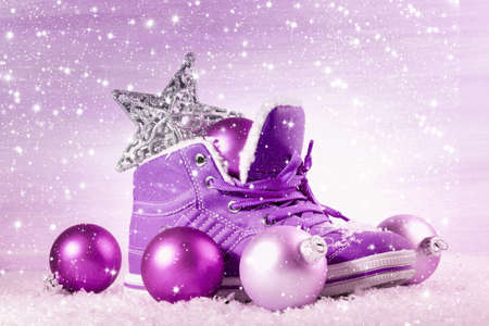 Purple shoe with Christmas decorations in the snow. Christmas background