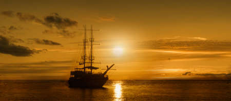 Panoramic image of a ship on a sunset backgroundの写真素材