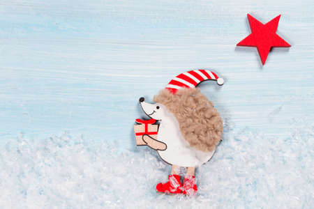 Christmas card with a hedgehog on a wooden background.の写真素材