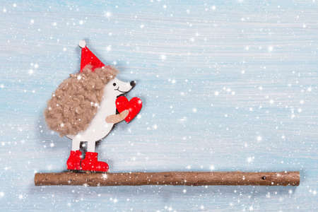 Christmas card with a hedgehog on a wooden background.の写真素材