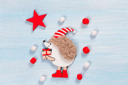 Christmas card with a hedgehog on a wooden background.の写真素材