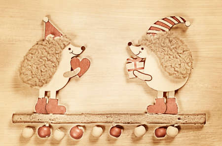 Christmas card with two hedgehogs on a wooden background. Vintage styleの写真素材
