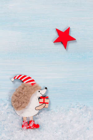 Christmas card with a hedgehog on a wooden background.の写真素材