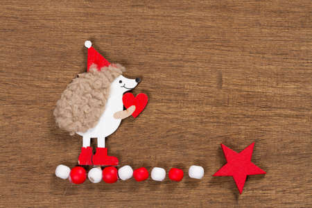 Christmas card with a hedgehog on a wooden background.の写真素材