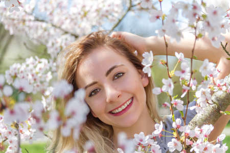Beautiful happy young woman in a flowering spring gardenの写真素材