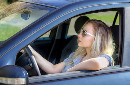 young woman driving a carの写真素材