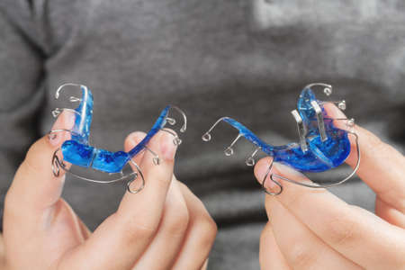 Child with orthodontic appliance. Boy holds an orthodontic appliance in his handの写真素材
