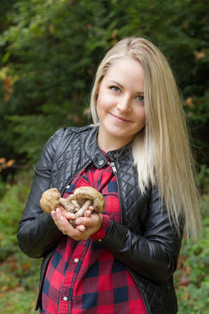 Portrait of a young pregnant woman in a forest with a mushroom cropの写真素材