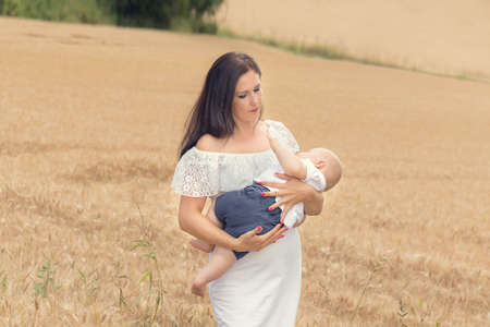 Mother with baby in a wheaten wheat field
