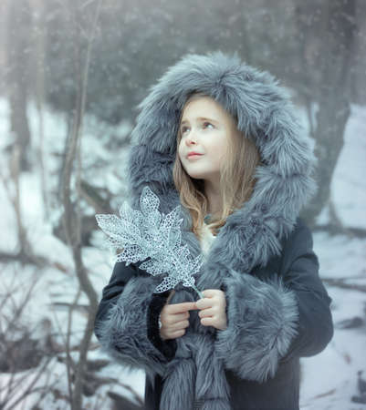 Portrait of a little girl in a fur coat.の写真素材