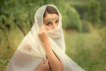 Young woman in tunic harvesting grapes
