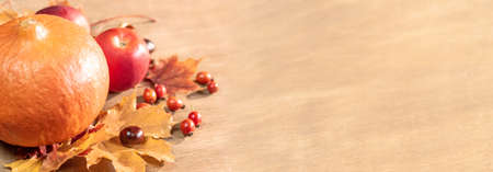 Autumn, autumn leaves, pumpkin and apples on a wooden table background. Panoramic image