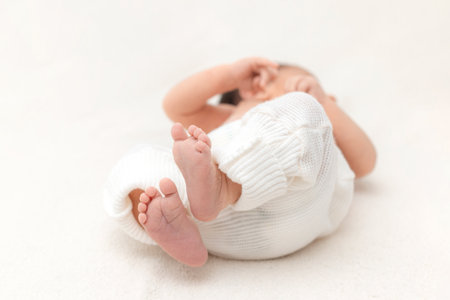 the baby's legs in the parents' armsの写真素材