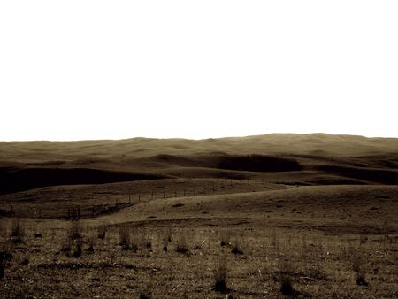 Prairie pasture with dead grass, rolling hills in the distance, with the sky a pale white. Sepia Toneの写真素材