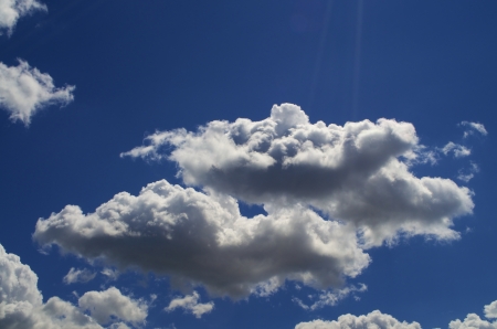 Light Blue sky with white clouds scattered throughout.の写真素材