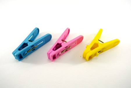 Three colorful clothes pegs over white backgroundの写真素材
