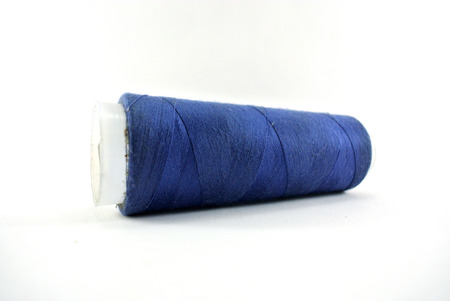 Blue spool of thread on white backgroundの写真素材
