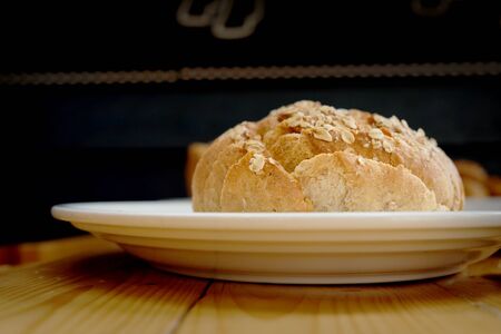 Baked bread on white plate and wooden table with Selective focus.