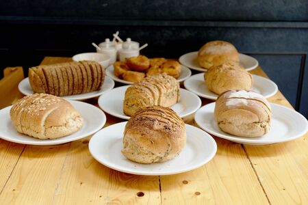 Baked bread on white plate and wooden table with Selective focus.