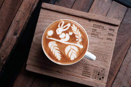 Top view of hot coffee cappuccino latte art on wooden table.の写真素材