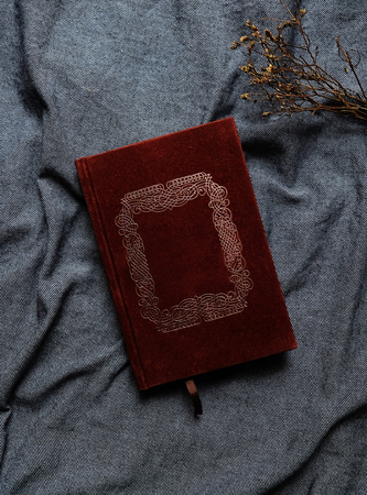 Old book cover in red canvas with embossed golden abstract decorations with copy space for text, Vintage tone.の写真素材