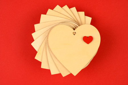 Valentine's Day background. a stack of wooden hearts on a red background. Valentine's Day concept. Flat view, top view, copy spaceの写真素材