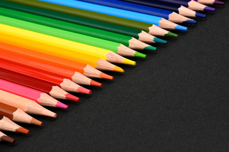 Crayons. Colored pencils on black cardboard background. Place for text. Education concept. High quality photo. Close-upの写真素材