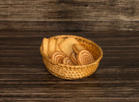 Cookies in a wicker basket on a wooden background.の写真素材