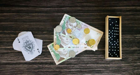 Money, cards and dominoes on the wooden backgroundの写真素材