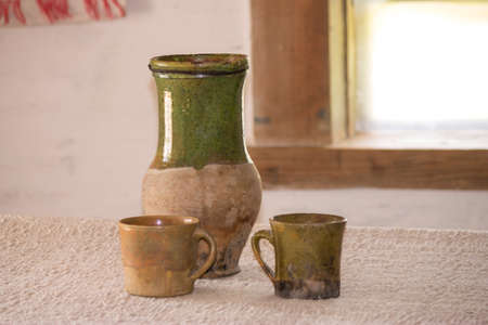 Clay jug and cups on the tableの写真素材
