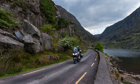 Motorcyclist driving through the winding roads of the gap of Dunloe in county Kerry, Irelandのeditorial素材
