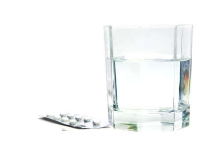 a couple of tablets with a glass of waterの写真素材