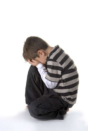 a young boy, sitting on the ground, cryingの写真素材