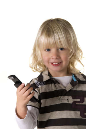 a young boy, laughing and holding a mobile phoneの写真素材