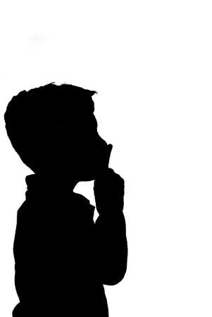 shh. secret - Young boy with his finger over his mouthの写真素材